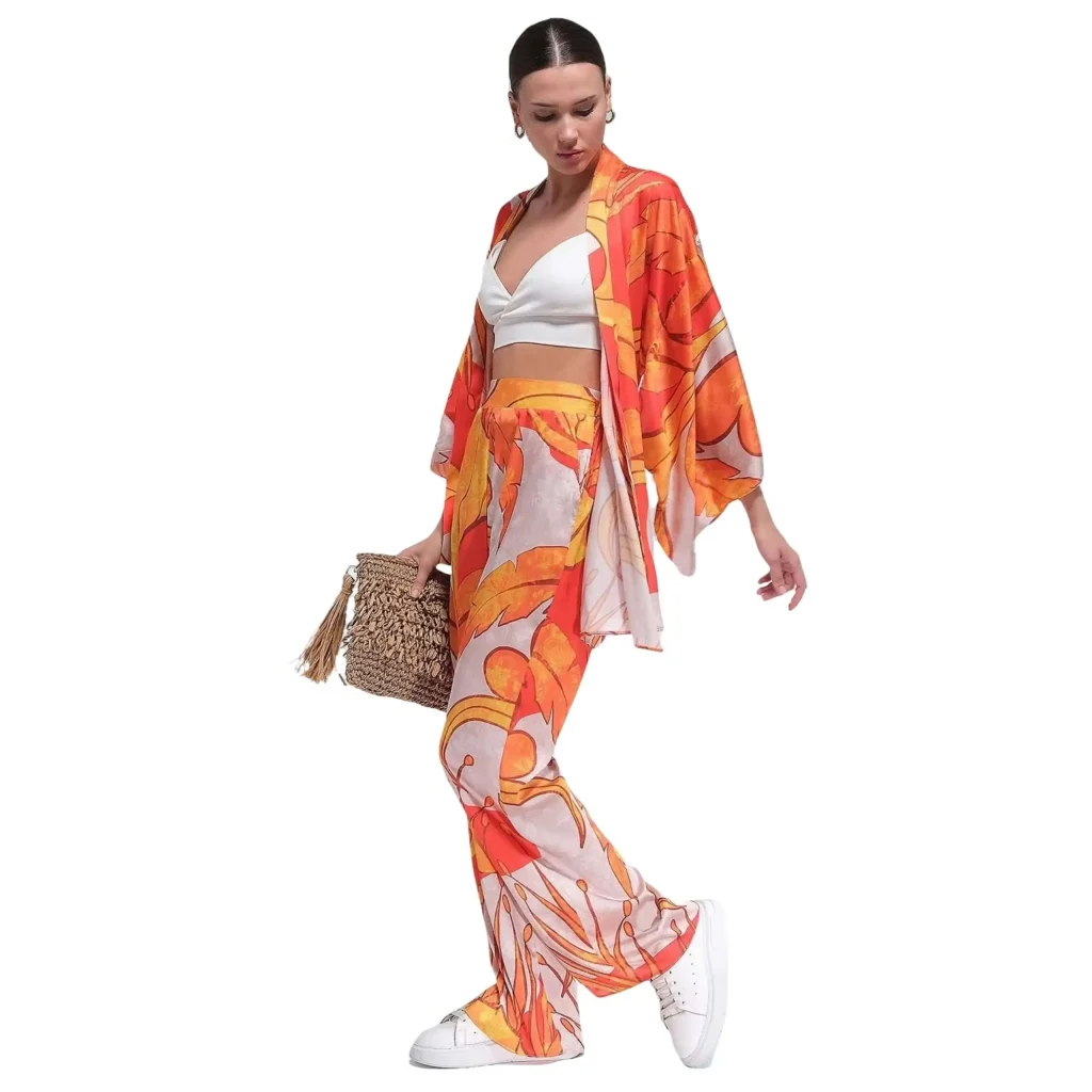Shop the Marcella patterned satin orange kimono wrap, featuring a vibrant floral design in shades of orange and yellow. This stylish kimono offers a relaxed fit with long sleeves and a comfortable tie belt for an adjustable waist. Ideal for casual wear or a beach cover-up, the light satin fabric provides a luxurious feel, while the bold print adds a statement to your outfit. Perfect for pairing with shorts, skirts, or flowy pants for a chic and effortless look.