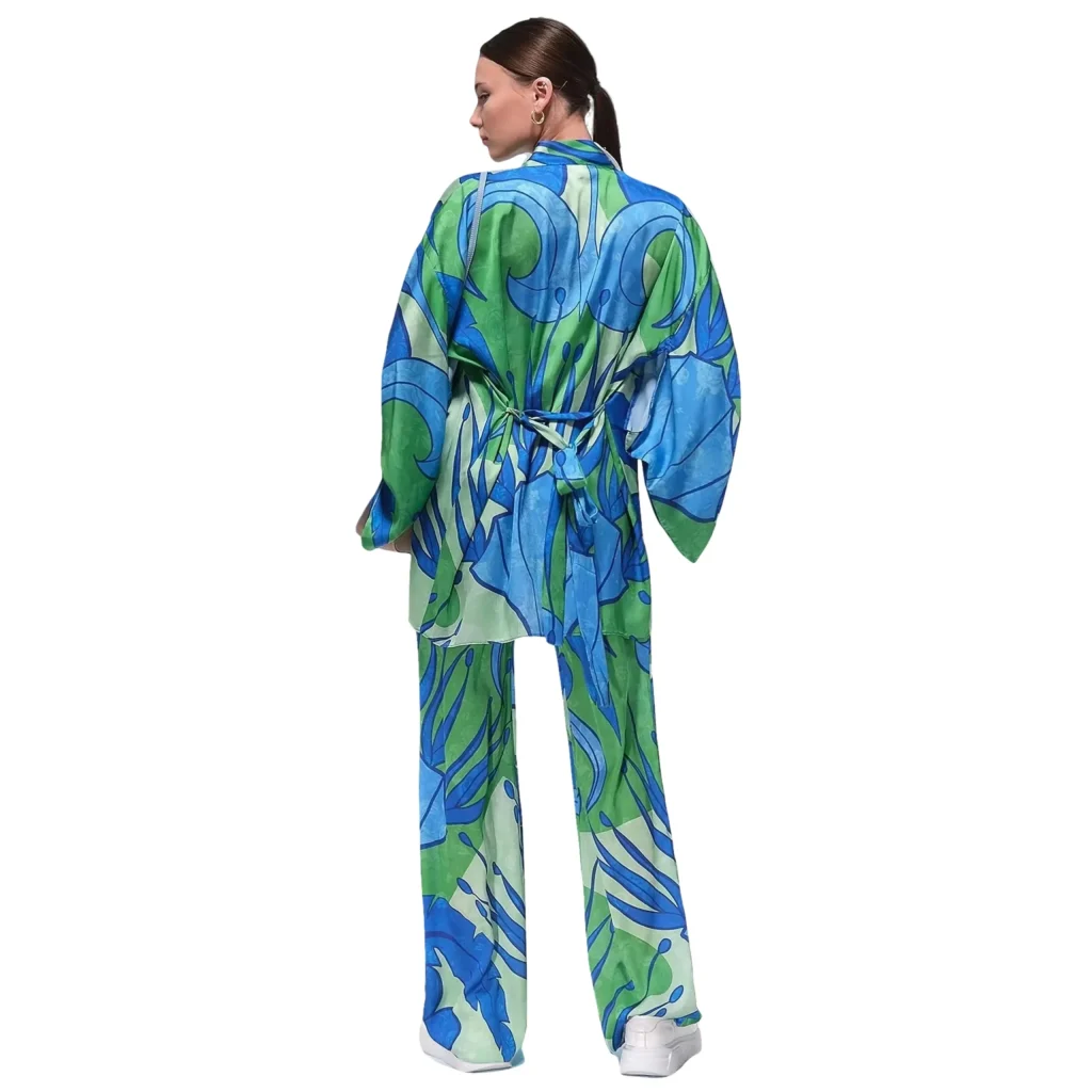 Shop the Olimpia printed relaxed pants in a stunning blue pattern, featuring a luxurious satin fabric for effortless style and comfort. These flowy, wide-leg pants showcase a dynamic design with shades of blue and green, creating a bold, tropical-inspired look. Perfect for a relaxed yet chic outfit, ideal for vacations, beach days, or casual outings. Pair with a simple top or kimono to elevate your summer wardrobe with this vibrant and fashionable piece.