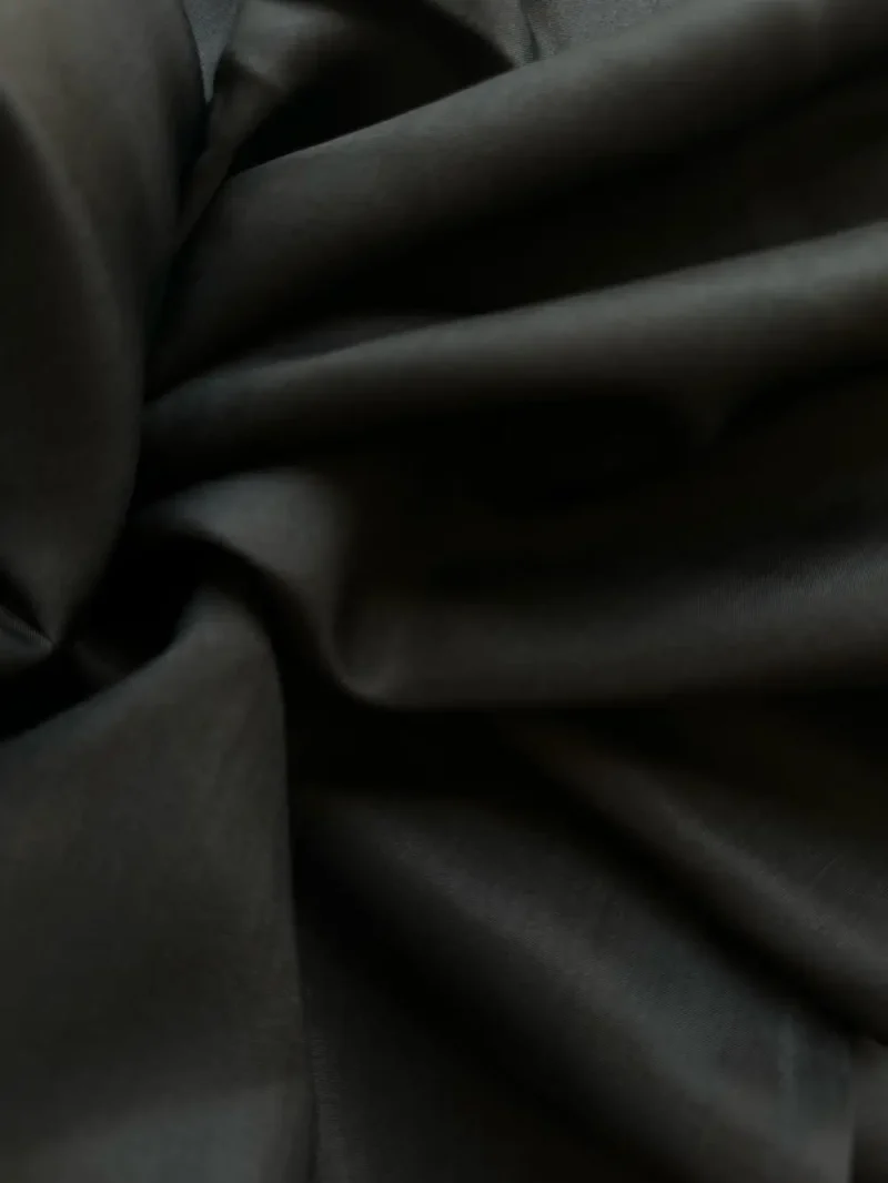 Silk Fabric Black Mulberry Silk Satin fabric draped to reveal fluidity and shine, perfect for luxury fashion pieces