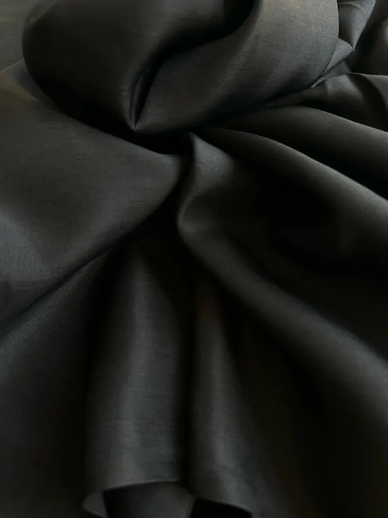 Close-up of black Italian Mulberry Silk Satin with smooth, lustrous surface, ideal for elegant garments