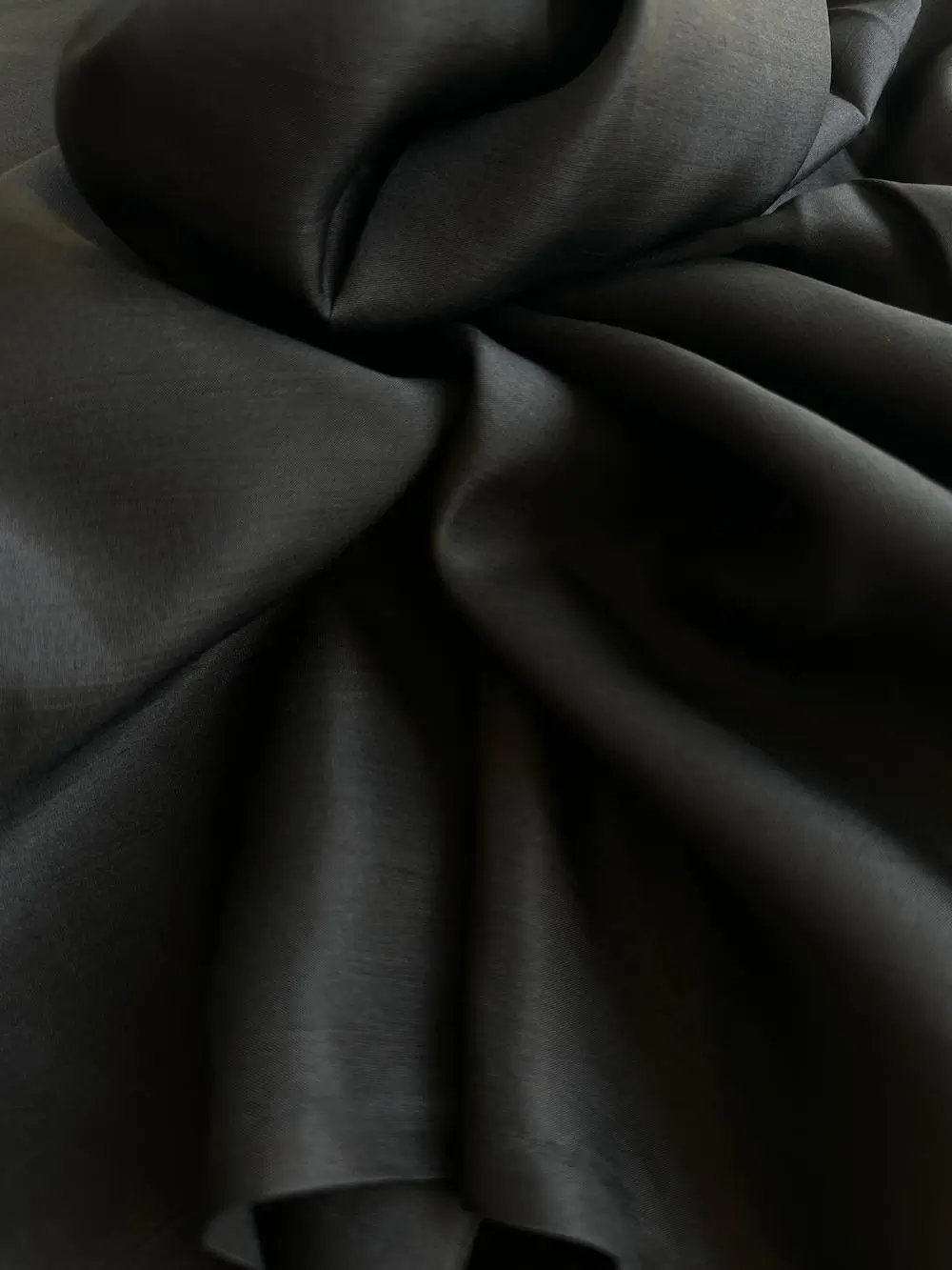 Close-up of black Italian Mulberry Silk Satin with smooth, lustrous surface, ideal for elegant garments