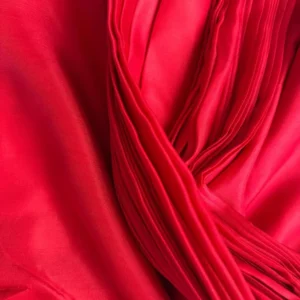 Close-up of ilk Fabric Red - Italian Mulberry Silk Satin with smooth glossy texture, ideal for dressmaking and tailored garments