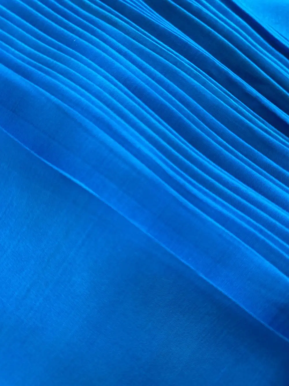 Silk Fabric Blue gracefully draped, showcasing its shine and soft movement