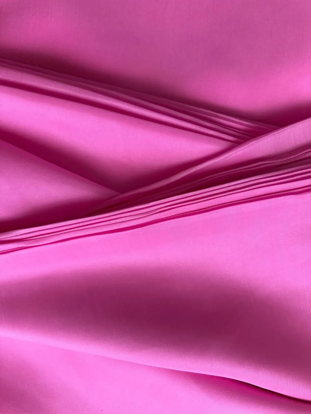 Rolled italian raspberry Silk Satin fabric with luxurious finish, ideal for shirts, skirts, or dresses