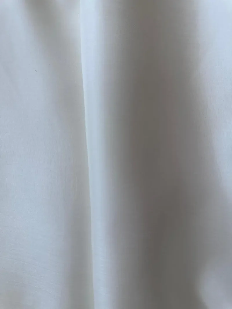 Close-up of off Silk Fabric White Italian Mulberry Silk Satin fabric with smooth texture and glossy finish, ideal for shirts and skirts